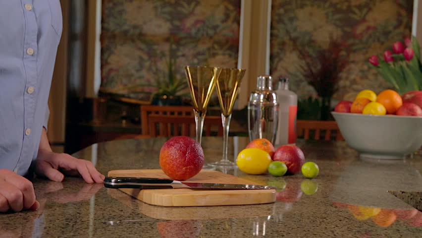 Woman slicing blood oranges for cocktails