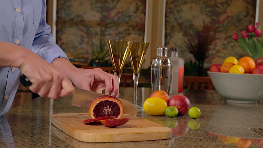 Woman slicing blood oranges for cocktails