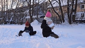 brother and sister playing with snow, fresh white snow on which children sit and make snowballs, childhood, winter in Europe, - Powered by Shutterstock - Get 15% off with code: PIKWIZARD15