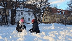 brother and sister playing with snow, fresh white snow on which children sit and make snowballs, childhood, winter in Europe, - Powered by Shutterstock - Get 15% off with code: PIKWIZARD15