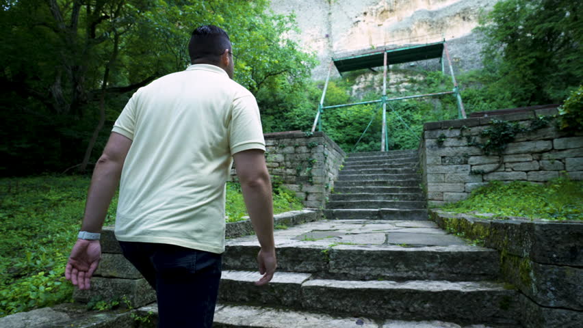 A tourist walks up the stairs towards the rock face of the Madara Plateau, where an ancient medieval rock relief called the Madara Rider can be found in Bulgaria.