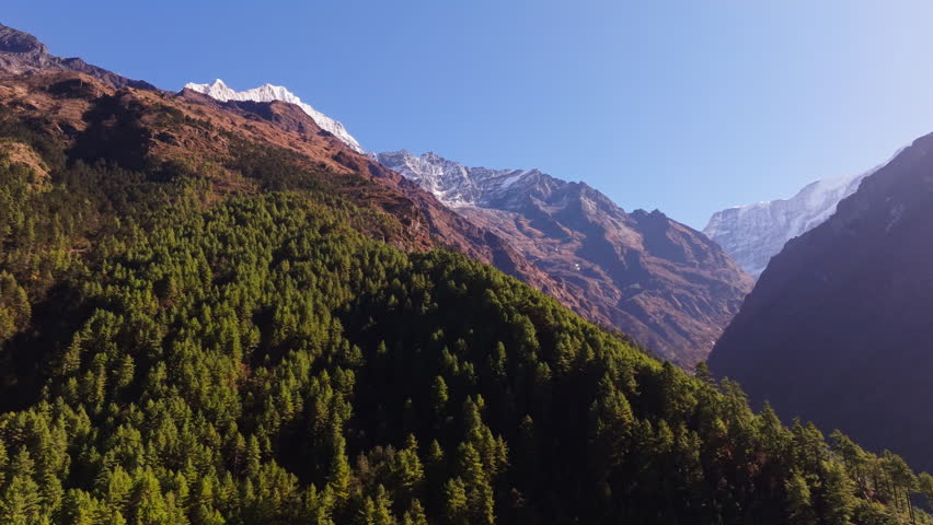 Majestic snow capped mountains towering over verdant valleys, revealing dramatic Himalayan terrain in Nepal