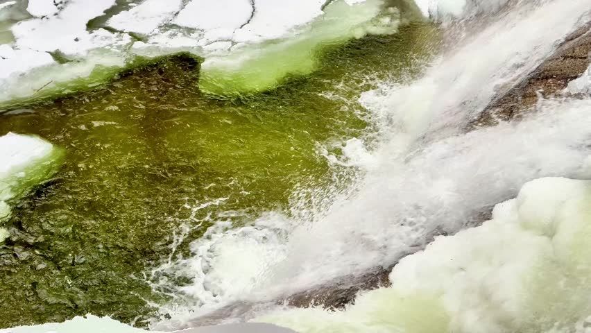 Mountain frozen waterfall in snowfall. High quality 4k footage