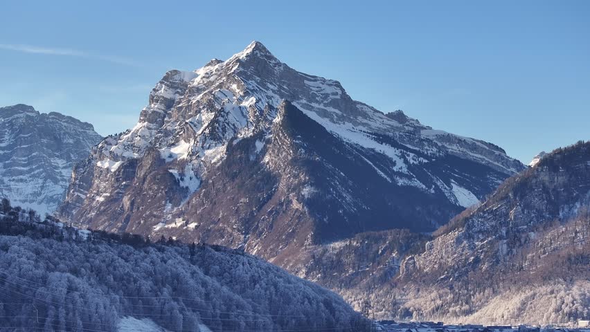 Aerial view of the majestic Rautispitz mountain in Switzerland, showcasing its snow-capped peak and its dramatic presence in the landscape.