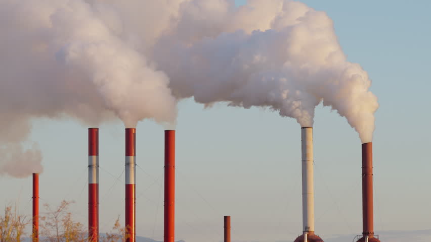 Industrial factory smokestacks billowing heavy smoke with sky background, Static shot
