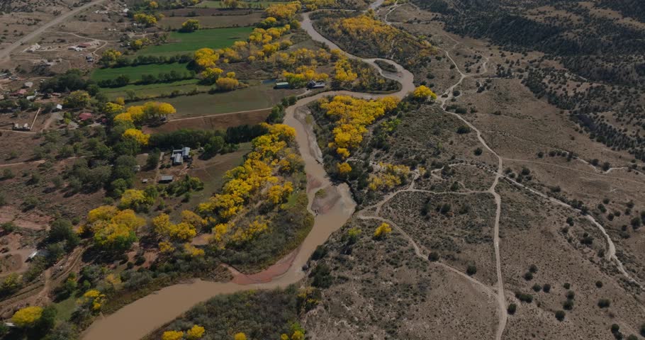 Aerial shot of vibrant yellow trees along winding roads in Abiquiu, New Mexico