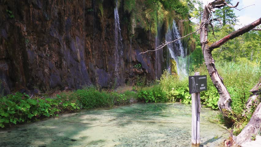 Boardwalk in Plitvice Lakes National Park, Croatia. Transparent Turquoise Colored Waters of the Lake Are Having Ripples. Many Small Waterfalls Flowing Into the Lake. Stedicam Shot