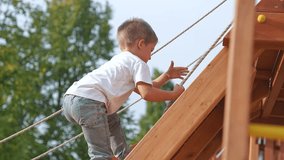 Child climbing rope playground. Child enjoys fun play outdoors. Child pulling rope developing strength coordination. Playful child at playground having fun climbing. Happy childhood outdoor adventure. - Powered by Shutterstock - Get 15% off with code: PIKWIZARD15
