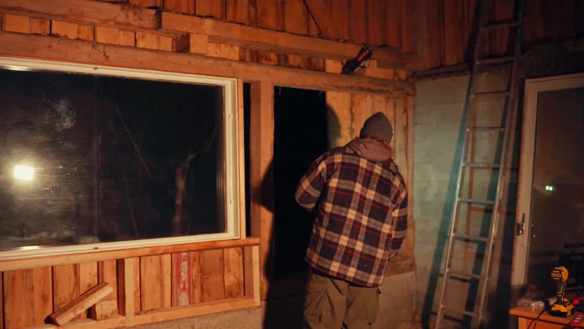 A Man is Installing a Wooden Plank to Serve as a Wall For the Rustic Barn - Timelapse