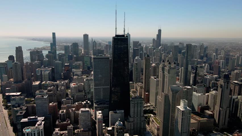 This aerial view showcases the impressive Chicago skyline, dominated by the towering Willis Tower (formerly Sears Tower). The city's dense urban landscape stretches out towards Lake Michigan.
