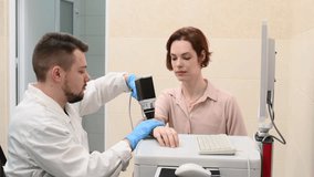 Male doctor examines neoplasms or moles on the woman patient's skin - using special apparatus for dermatoscopy digital dermoscope. Prevention of melanoma and skin cancer. World Cancer Day	 - Powered by Shutterstock - Get 15% off with code: PIKWIZARD15