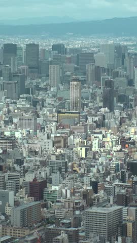 OSAKA, JAPAN : Aerial high angle view of CITYSCAPE of OSAKA in daytime. View of building and street around Namba, Shinsaibashi, Umeda and Osaka train station. Vertical shot.