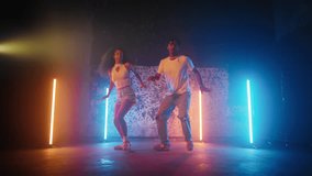 People dancing reggaeton and dancehall in dance studio, black man and woman. Active dance performance, African American dancers performing modern choreography, street style dance, slow motion shot - Powered by Shutterstock - Get 15% off with code: PIKWIZARD15