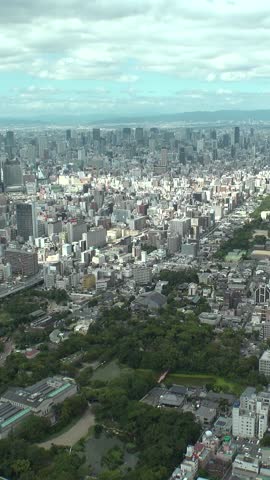 OSAKA, JAPAN : Aerial high angle view of CITYSCAPE of OSAKA in daytime. View of building and street around Namba, Shinsaibashi, Umeda and Osaka train station. Vertical time lapse shot from above.