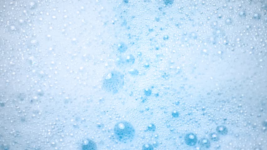 White soap foam float in water. Concept of cleaning and washing. Abstract soap suds moving in a circle.
