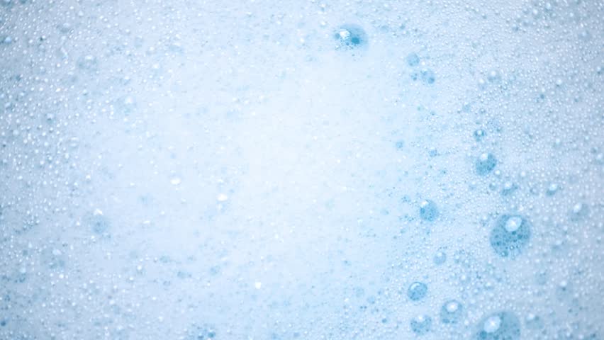 White soap foam float in water. Concept of cleaning and washing. Abstract soap suds moving in a circle.