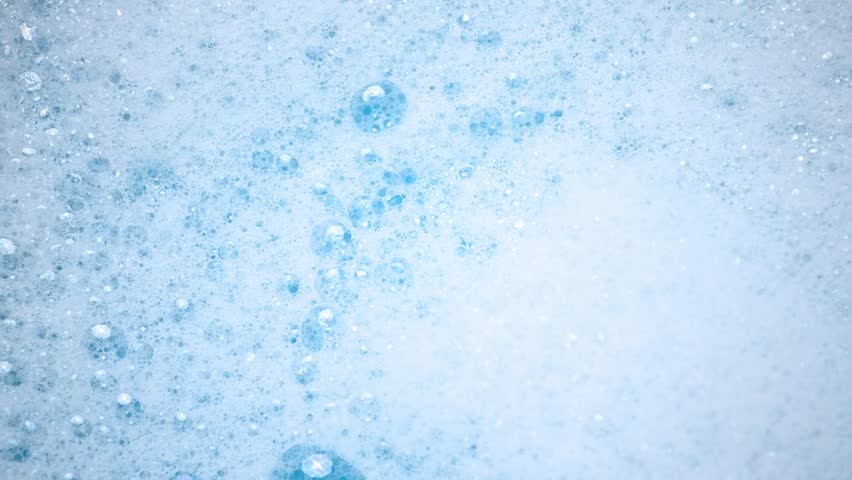 Soap suds in water, bubbles float and burst Abstract white soap foam texture. Concept of cleaning and washing.