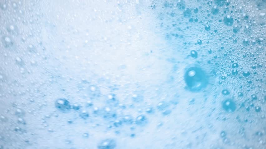 Soap suds in water, bubbles float and burst Abstract white soap foam texture. Concept of cleaning and washing.