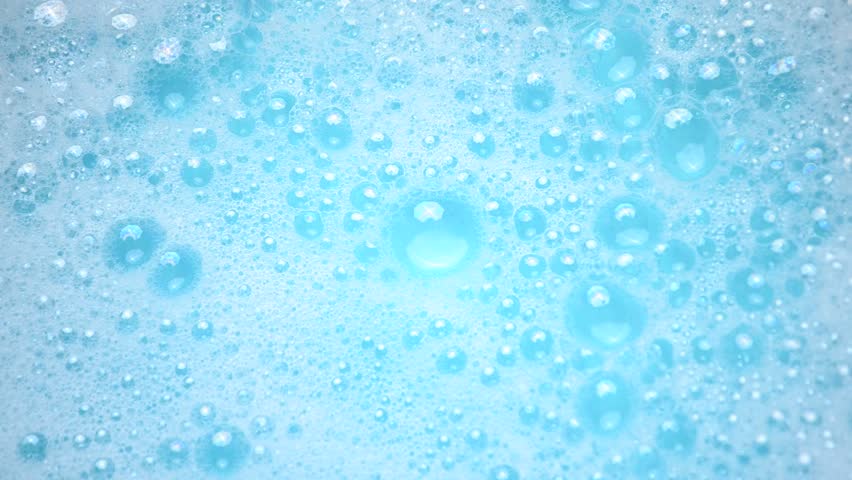 Soap suds in water, bubbles float and burst Abstract white soap foam texture. Concept of cleaning and washing.