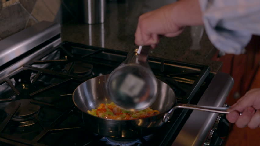 Man sauteing and flambeing vegetables
