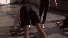 Group training. Sport instructor. Female coach help people stretch asana pose downward facing dog exercise balance on mat in gym fitness studio indoors. - Powered by Shutterstock - Get 15% off with code: PIKWIZARD15