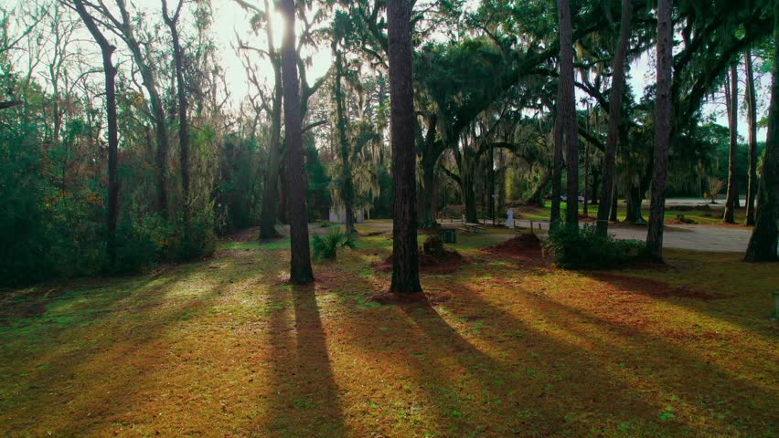 Orbiting aerial Smallest Church in America Nestled Among Spanish Moss-Draped Oaks at Golden Hour in Georgia's Wilderness