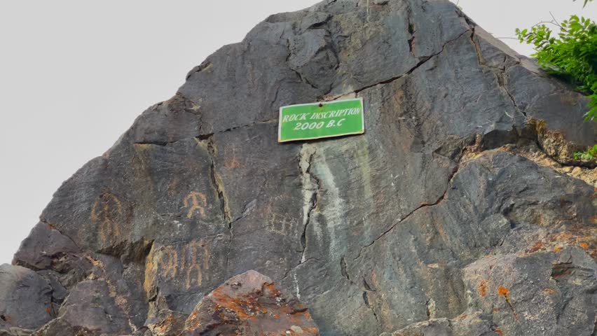 Rock inscription from the bronze age with petroglyphs carved on a large rock, providing a glimpse into ancient history