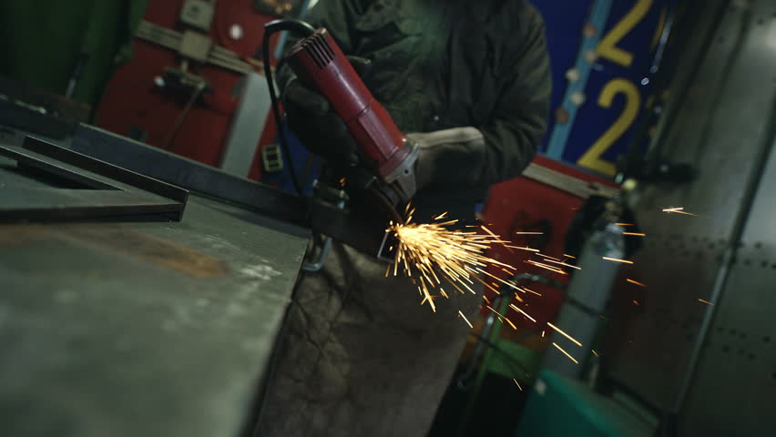 Sparkles, glowing hot steel dust, getting on the camera while a welder grinding or cutting metal, static shot. Metalwork, manual, and craft concepts.