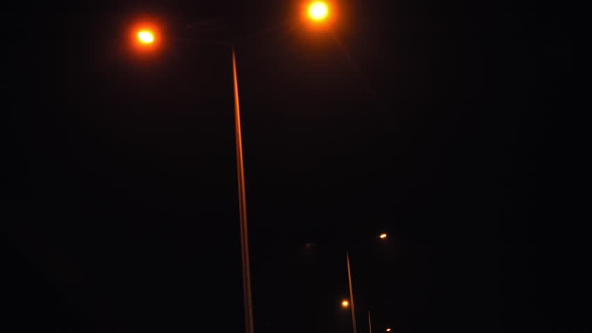 Night Drive on Mountain Highway City Lights and Street Lamps Illuminating the Road