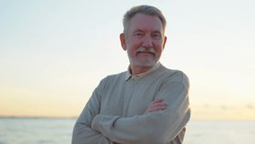 Outdoor portrait of confident stylish European middle aged senior man on beach. Older mature man smiling. Happy senior grandfather looking at camera close up face headshot portrait. Happy people - Powered by Shutterstock - Get 15% off with code: PIKWIZARD15