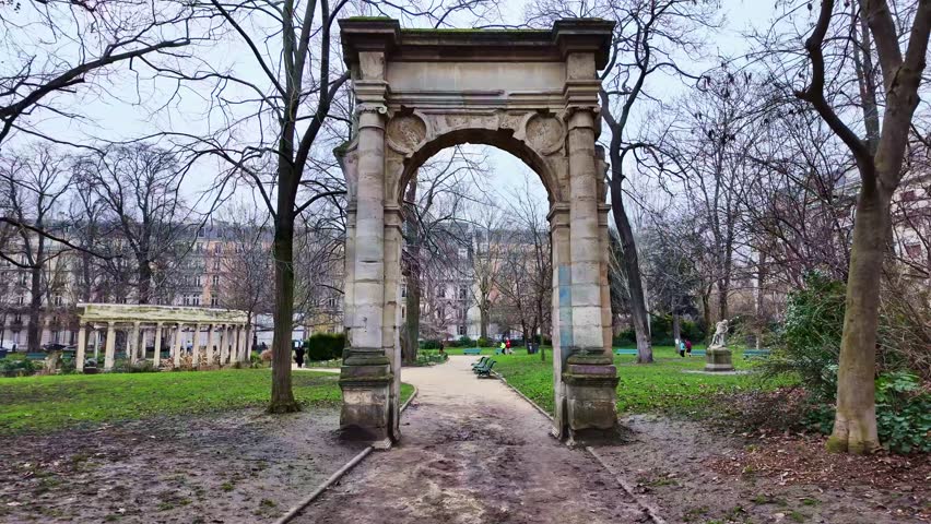 Ancient stone archway entrance in the historic Parc Monceau public park, Paris, France.