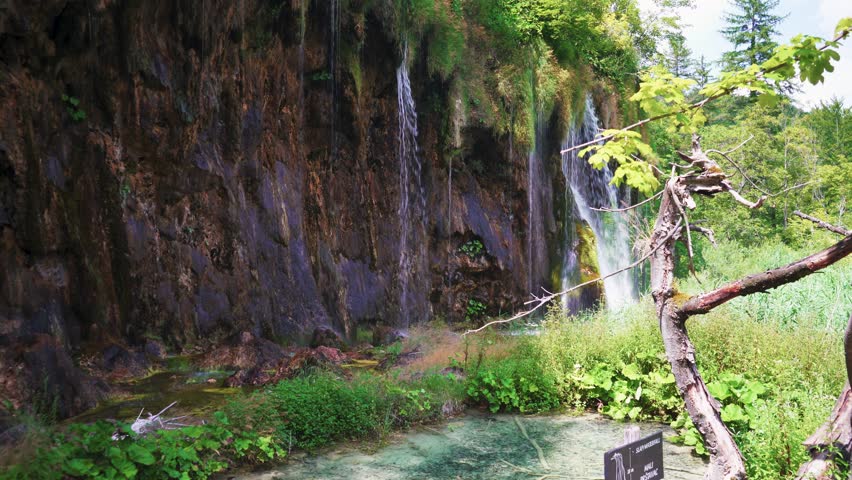 Boardwalk in Plitvice Lakes National Park, Croatia. Transparent Turquoise Colored Waters of the Lake Are Having Ripples. Many Small Waterfalls Flowing Into the Lake. Stedicam Shot