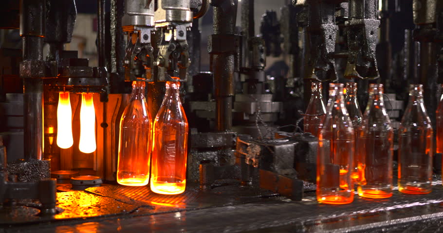 High-temperature glass bottle manufacturing process showcasing molten glass shaping, precision machinery, and an automated production line in an industrial factory setting