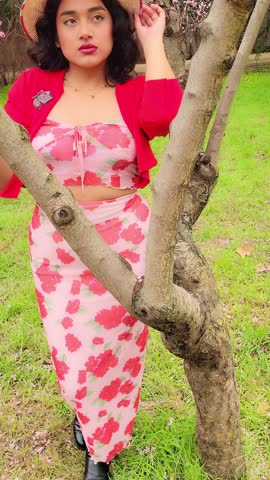 Woman wearing her pamela in field of cherry and almond blossoms.