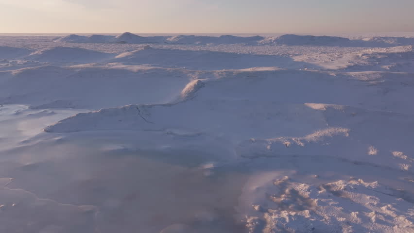 Frozen landscape over Lake Huron, serene, snow-covered, with distant hills