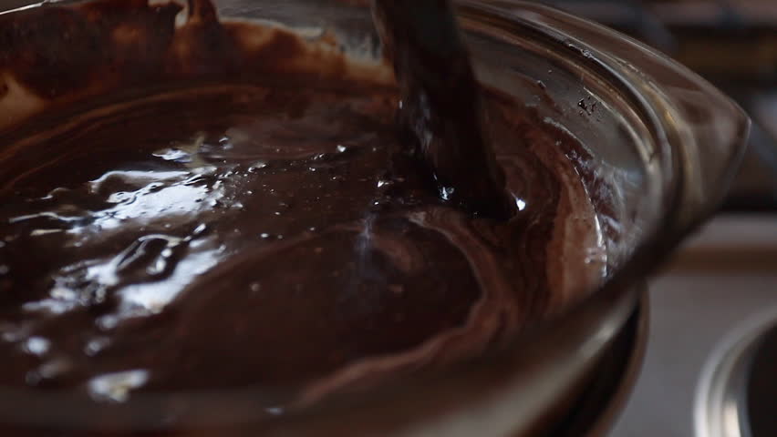 Closeup: Spatula stirs rich milk chocolate melted in double boiler pan