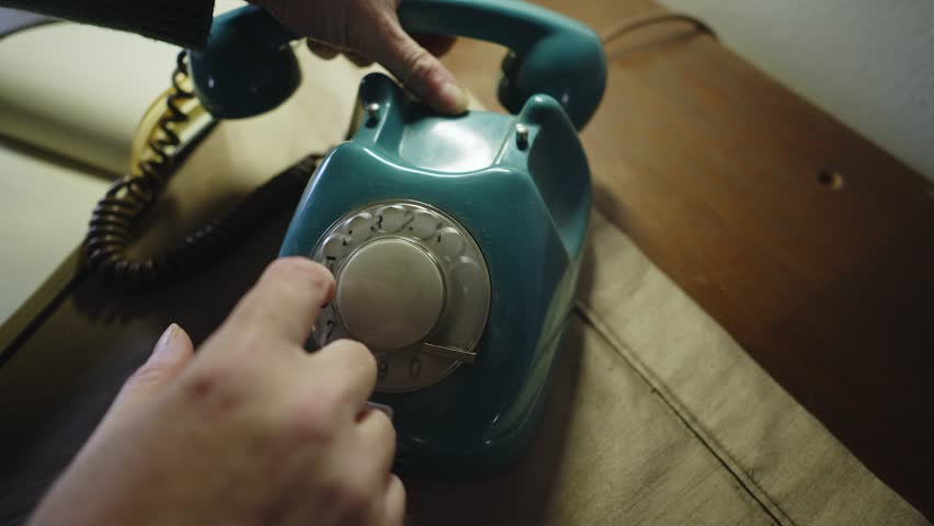 Man dials number on retro telephone then quickly hangs up hand set Close up shot