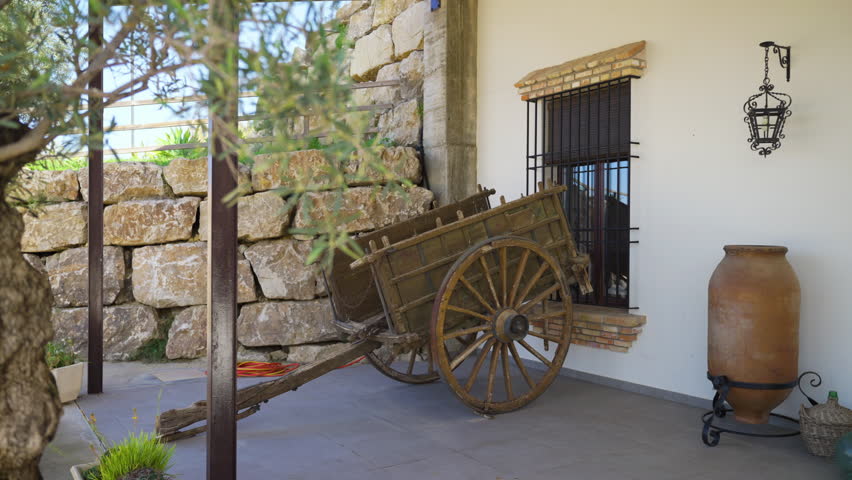 Old wooden cart and farm buildings of olive production, handheld