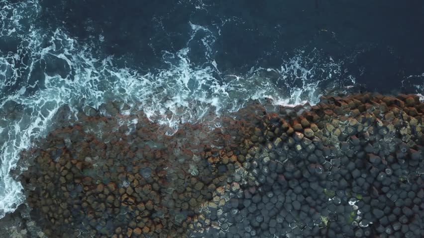 Aerial top down of The Giant Causeway volcanic fissure eruption cliff rock formation in County Antrim on the north coast of Northern Ireland