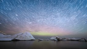 Scenic timelapse. Star trails above the sea with melting ice floes. - Powered by Shutterstock - Get 15% off with code: PIKWIZARD15
