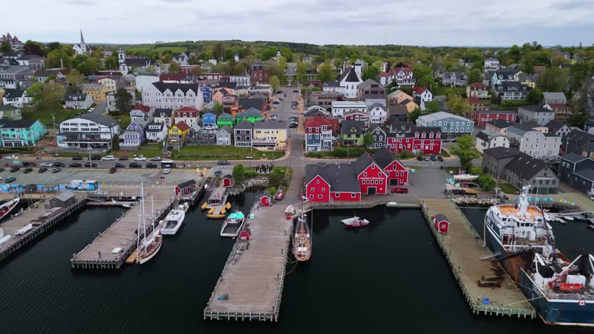 Aerial Footage Of The Historic Town Of Lunenburg, Nova Scotia, On A Cloudy Summer Day. The Scenic Coastal Views And Vibrant Buildings Showcase The Charm Of This UNESCO World Heritage Site.