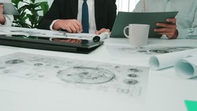 A group of business professionals engage in a collaborative meeting in a modern office setting. They review documents, use digital devices, and discuss project strategies. SACTR - Powered by Shutterstock - Get 15% off with code: PIKWIZARD15