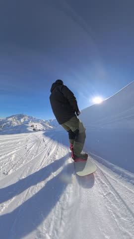 Dynamic snowboarding action as skilled rider carves through fresh powder on scenic alpine track, embodying freedom, adrenaline, and passion for winter sports in perfect weather. Vertical shot