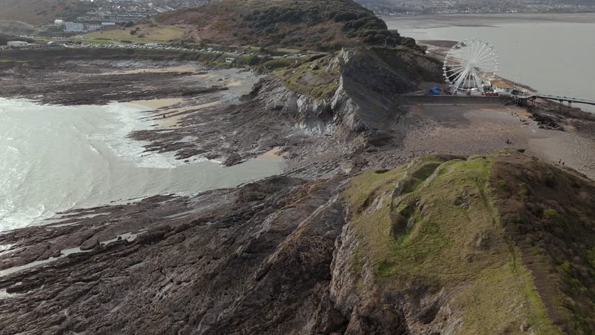 Drone shot of The Big Wheel at Mumbles Pier Swansea in United Kingdom during daytime.
