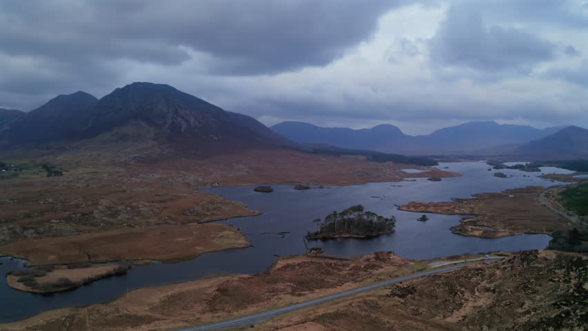 Wide aerial orbit over Connemara National Park at twilight, featuring serene lakes and majestic mountains