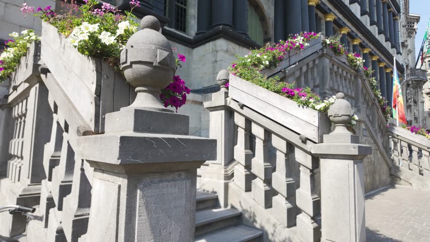 A historic City Hall in Ghent, Belgium, with floral-decorated staircases in sunlight