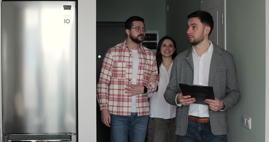 Young couple with real-estate agent visiting apartment for sale or for rent. Loving people buying an apartment. Real estate concept.