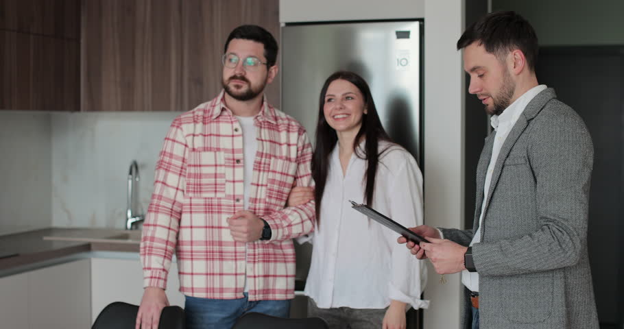 Young couple with real-estate agent visiting apartment for sale or for rent. Loving people buying an apartment. Real estate concept.