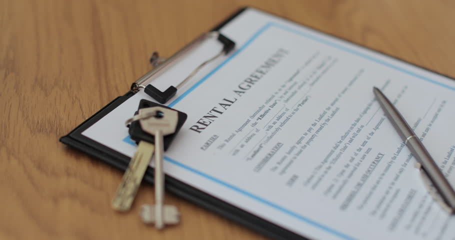 Close-up view of a rental agreement document with key, and a pen placed on top. Property rental, leasing contracts, real estate.