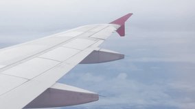 view through plane window from inside airplane cabin while climbing flying over the sky with airplane wing winglet and fluffy cloud outside in summer daytime - Powered by Shutterstock - Get 15% off with code: PIKWIZARD15